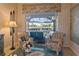 Living room with floral armchairs, a glass coffee table, and sliding doors leading to a pool at 13761 Long Lake Ln, Port Charlotte, FL 33953