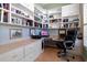 Bright home office with custom built-in bookshelves, storage, desk space, and an ergonomic office chair at 13761 Long Lake Ln, Port Charlotte, FL 33953