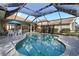 Relaxing kidney shaped pool with screened enclosure and patio at 13761 Long Lake Ln, Port Charlotte, FL 33953