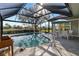 Inviting pool area with screened enclosure and patio furniture at 13761 Long Lake Ln, Port Charlotte, FL 33953