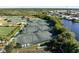 Aerial view of tennis courts surrounded by lush greenery, providing an excellent recreational amenity for residents at 13761 Long Lake Ln, Port Charlotte, FL 33953