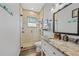 Modern bathroom with granite vanity, glass shower, and stained-glass window at 1531 Aqui Esta Dr # 1, Punta Gorda, FL 33950