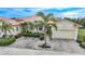 Front view of charming house with a two-car garage and lush landscaping at 1531 Aqui Esta Dr # 1, Punta Gorda, FL 33950