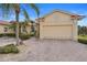 Light yellow house with a two-car garage and palm trees at 1531 Aqui Esta Dr # 1, Punta Gorda, FL 33950