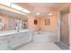 Bathroom with a corner bathtub, shower, and white cabinets at 16253 Cape Horn Blvd, Punta Gorda, FL 33955