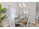 Elegant dining room featuring a wood table, white chairs, and a chandelier at 18322 Garman Ave, Port Charlotte, FL 33948