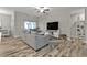 Spacious living room with gray sofa and wood-look tile floors at 18322 Garman Ave, Port Charlotte, FL 33948