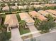 Aerial view of three houses, showing tile roofs and landscaping at 19119 Mangieri St, Venice, FL 34293