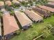 Aerial view of three houses with tile roofs and lush green lawns at 19119 Mangieri St, Venice, FL 34293