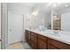 Double vanity bathroom with a large mirror and tiled shower at 19119 Mangieri St, Venice, FL 34293