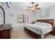 Main bedroom with ceiling fan, large windows, and wood furniture at 19119 Mangieri St, Venice, FL 34293