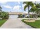 Tan single-story house with a two-car garage and lush landscaping at 195 Bayshore Ct, Punta Gorda, FL 33950