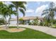 Single-story home with palm trees, circular driveway, and landscaped lawn at 195 Bayshore Ct, Punta Gorda, FL 33950