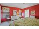 Main bedroom with red walls and floral bedding at 2100 Kings Hwy # 100, Port Charlotte, FL 33980