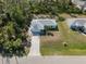 House with driveway and yard, surrounded by lush green trees at 2529 Flagami Ln, North Port, FL 34286