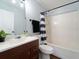 Bathroom with tub shower combo, wood-look flooring, and dark vanity at 2529 Flagami Ln, North Port, FL 34286