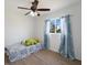 Cozy bedroom with a twin-size bed, ceiling fan, and light-blue curtains at 2529 Flagami Ln, North Port, FL 34286