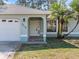 House front showcasing a light teal exterior, a paved driveway, and lush lawn at 2529 Flagami Ln, North Port, FL 34286