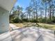 Back patio with a walkway leading to a wooded area at 2529 Flagami Ln, North Port, FL 34286