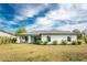 House back view, showcasing backyard patio, landscaping, and grassy area at 25896 Prada Dr, Punta Gorda, FL 33955