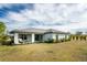 House back view, showcasing backyard patio, landscaping, and grassy area at 25896 Prada Dr, Punta Gorda, FL 33955