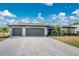 House front view with a two-car garage and nicely landscaped yard at 25896 Prada Dr, Punta Gorda, FL 33955