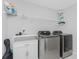 Bright laundry room with washer, dryer, and shelving at 25896 Prada Dr, Punta Gorda, FL 33955