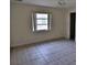 A bedroom with tile flooring and a window with blinds at 27446 Pasto Dr, Punta Gorda, FL 33983