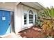 Front entrance with blue door and hurricane shutters at 27446 Pasto Dr, Punta Gorda, FL 33983