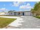 Newly renovated home with gray exterior, white columns, and a large driveway at 3112 Magnolia Way, Punta Gorda, FL 33950