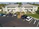 Aerial view of condo building with parking lot and surrounding landscape at 3310 Loveland Blvd # 1604, Punta Gorda, FL 33980