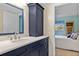 Bathroom with navy vanity, quartz countertop and a view of bedroom at 3310 Loveland Blvd # 1604, Punta Gorda, FL 33980