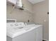 Functional laundry room with washer, dryer, and overhead shelving at 3450 Moravia Ave, North Port, FL 34286