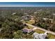 Aerial view of a residential area featuring houses and roads surrounded by lush greenery at 4198 Kinlock St, North Port, FL 34286