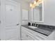 Updated bathroom with granite countertop, white cabinets, and a large mirror at 4198 Kinlock St, North Port, FL 34286