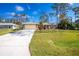 House exterior with a driveway and lush green lawn at 4198 Kinlock St, North Port, FL 34286