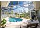 Relaxing screened-in pool area with patio furniture at 4198 Kinlock St, North Port, FL 34286