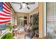 Bright screened porch with wicker chairs and American flag at 4258 Mermell Cir, North Port, FL 34291