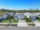 Aerial view of houses with gray roofs, paved driveways, and lush green lawns at 43783 Cattleman Dr, Punta Gorda, FL 33982