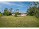 Large backyard with grassy lawn and mature trees at 4401 Boeing Ln, North Port, FL 34287