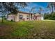 Tan house with a screened front porch and lush green lawn at 4401 Boeing Ln, North Port, FL 34287