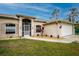 House exterior showcasing a tan elevation, landscaped yard and attached garage at 4401 Boeing Ln, North Port, FL 34287