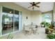 Relaxing screened porch with seating area, ceiling fan, and lush potted plants at 4401 Boeing Ln, North Port, FL 34287