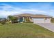 Single-story home with three-car garage, teal front door, and manicured lawn at 45 Marker Rd, Rotonda West, FL 33947