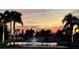 Sunset view of community lake with fountain and palm trees at 4530 Turnberry Cir, North Port, FL 34288