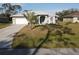 One story house with a light gray exterior, white garage door, and palm trees in front at 4607 Sabrina Ter, North Port, FL 34286