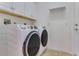 Bright laundry room with white washer and dryer, cabinets, and tile floor at 4607 Sabrina Ter, North Port, FL 34286