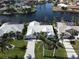 Aerial view of a waterfront house with palm trees and a canal at 506 Monaco Dr, Punta Gorda, FL 33950