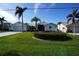 Front view of a house with a landscaped yard and palm trees at 506 Monaco Dr, Punta Gorda, FL 33950