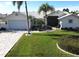 White house with palm trees, large lawn, and a paved driveway at 506 Monaco Dr, Punta Gorda, FL 33950